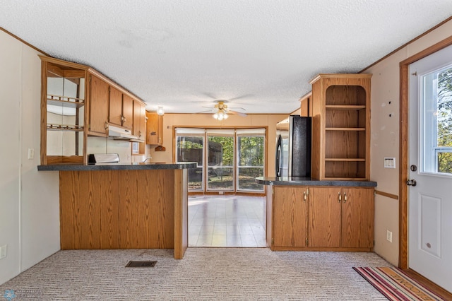 kitchen featuring stainless steel refrigerator, kitchen peninsula, and a textured ceiling