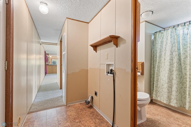 bathroom featuring a textured ceiling, toilet, and walk in shower