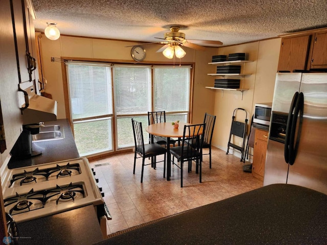 dining room featuring a textured ceiling, sink, and ceiling fan