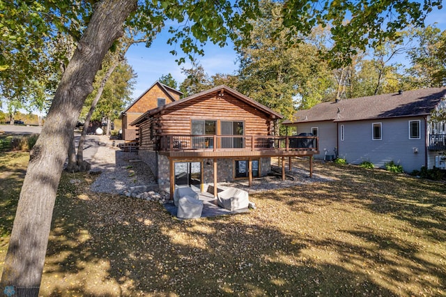 rear view of house with a wooden deck and a yard