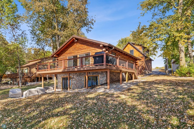 rear view of property with a wooden deck and a yard