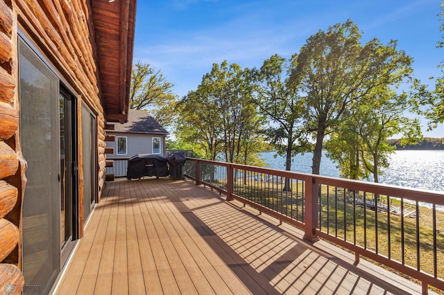 wooden terrace with a water view and area for grilling