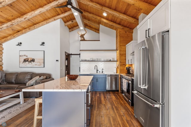 kitchen featuring premium appliances, dark hardwood / wood-style floors, white cabinets, and a breakfast bar