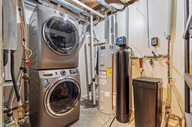 clothes washing area with stacked washer and dryer and electric water heater