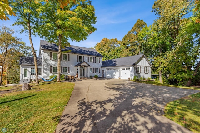 colonial-style house with a front yard and a garage