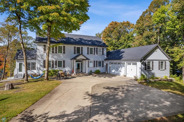 colonial-style house with a front yard and a garage