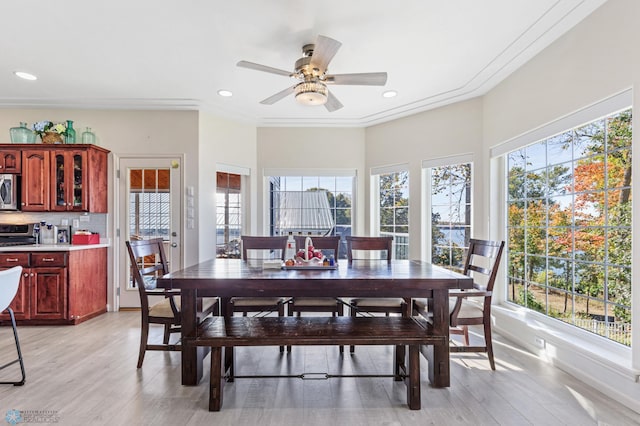 dining room featuring light hardwood / wood-style flooring, ornamental molding, a healthy amount of sunlight, and ceiling fan