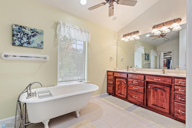 bathroom with vanity, vaulted ceiling, a tub to relax in, and ceiling fan