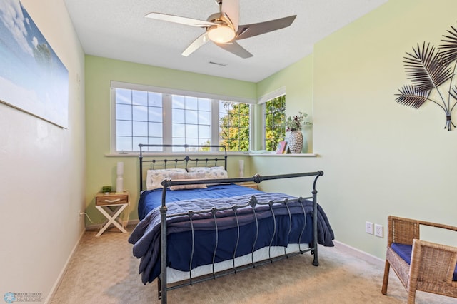 carpeted bedroom with a textured ceiling and ceiling fan