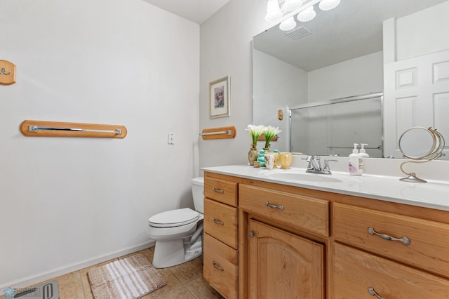 bathroom featuring vanity, walk in shower, toilet, and tile patterned flooring