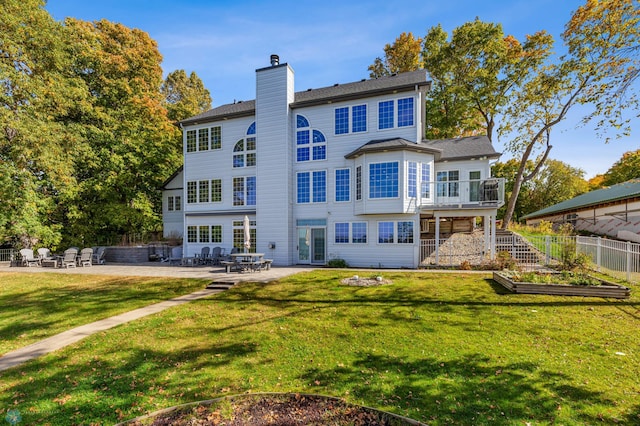 rear view of house featuring a patio area and a lawn