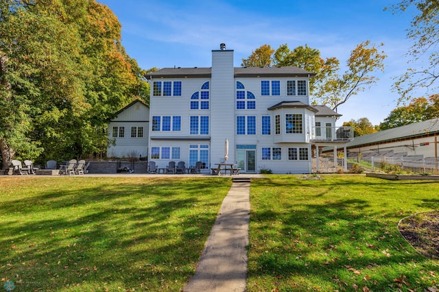 rear view of property featuring a yard and a patio