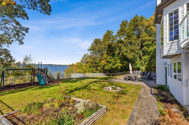 view of yard featuring a water view, a patio area, and a playground