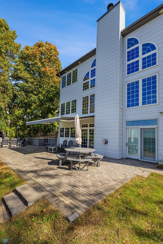 rear view of house featuring a patio and a yard