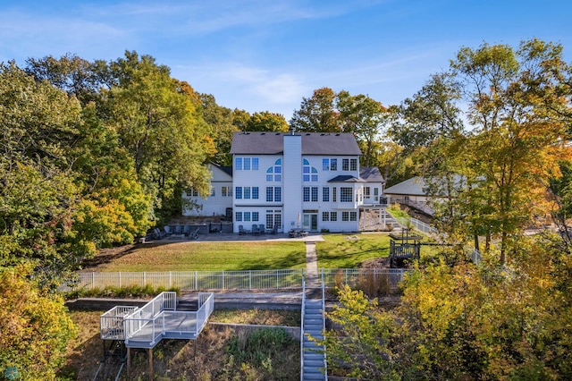 rear view of house featuring a patio and a lawn