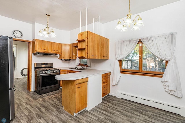 kitchen featuring kitchen peninsula, baseboard heating, appliances with stainless steel finishes, a notable chandelier, and dark hardwood / wood-style flooring