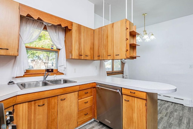 kitchen featuring pendant lighting, sink, kitchen peninsula, stainless steel dishwasher, and hardwood / wood-style floors