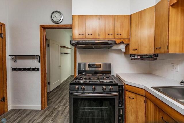 kitchen featuring stainless steel gas stove, dark hardwood / wood-style flooring, sink, and tasteful backsplash