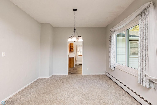 spare room with a notable chandelier, baseboard heating, and carpet floors