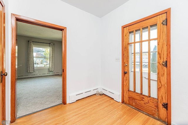 interior space featuring baseboard heating and light hardwood / wood-style flooring