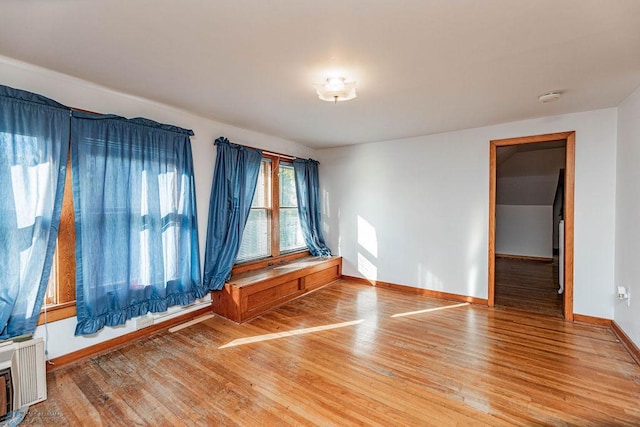 empty room with wood-type flooring and radiator heating unit