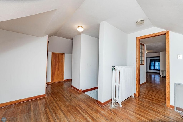 bonus room featuring radiator, vaulted ceiling, and hardwood / wood-style flooring