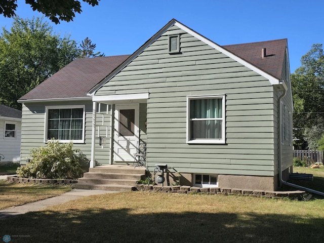 rear view of house featuring a lawn