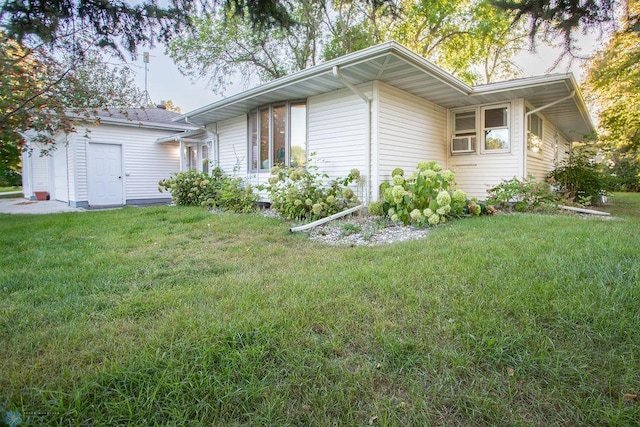 view of side of property featuring cooling unit and a yard