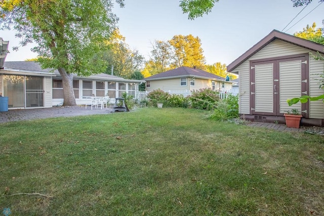 view of yard featuring a storage shed, a sunroom, and a patio area