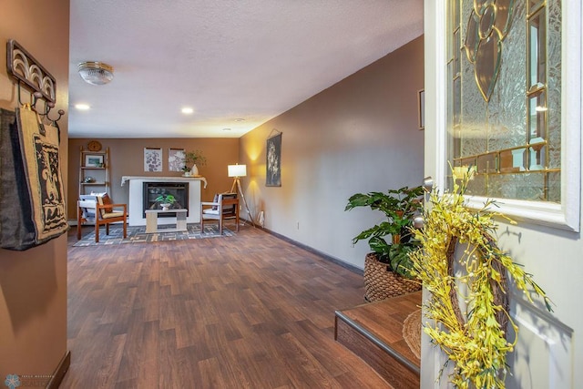 living room featuring a fireplace, dark wood-type flooring, and a healthy amount of sunlight