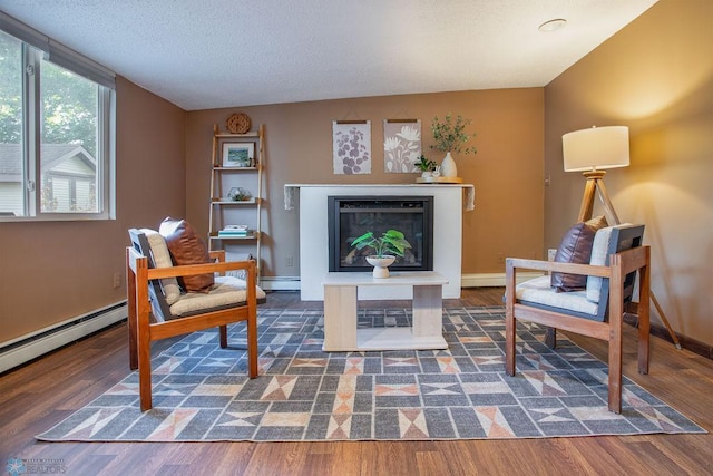 living area with lofted ceiling, a baseboard radiator, dark wood-type flooring, and a textured ceiling