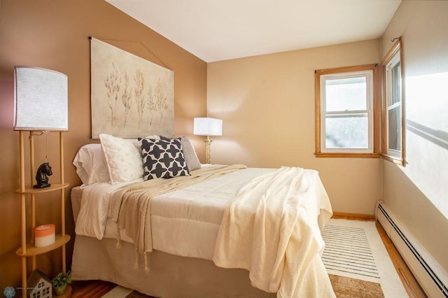 bedroom with vaulted ceiling, hardwood / wood-style floors, and a baseboard radiator