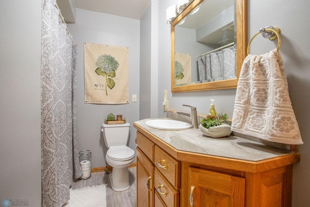 bathroom featuring wood-type flooring, vanity, and toilet