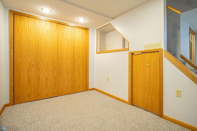 bonus room featuring a textured ceiling and carpet flooring