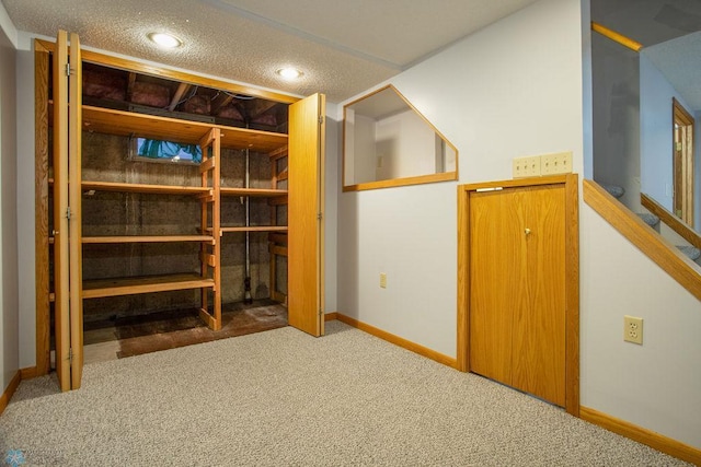 bonus room with a textured ceiling and carpet flooring