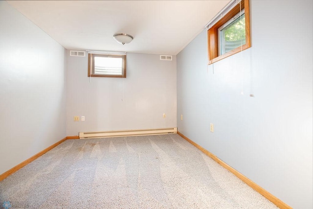 basement with carpet floors and a baseboard heating unit