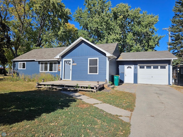 view of front facade with a front yard, a garage, and a deck