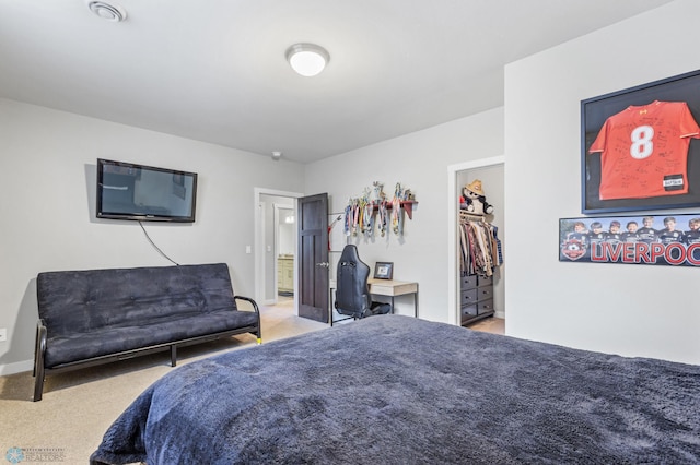 bedroom with light colored carpet, a closet, and a walk in closet