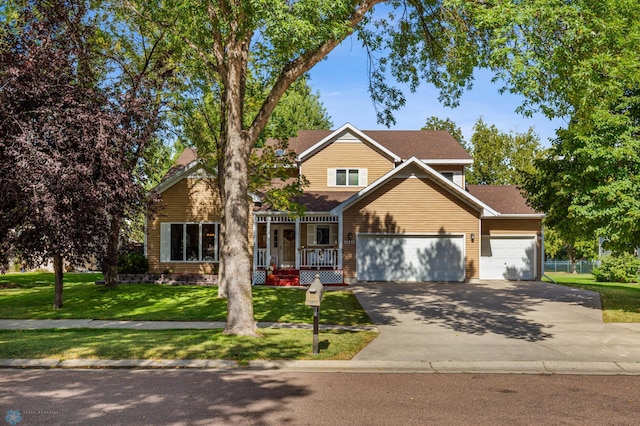 view of front of home with a front yard, a garage, and a porch