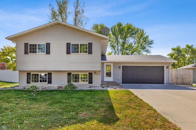 tri-level home featuring a garage and a front lawn