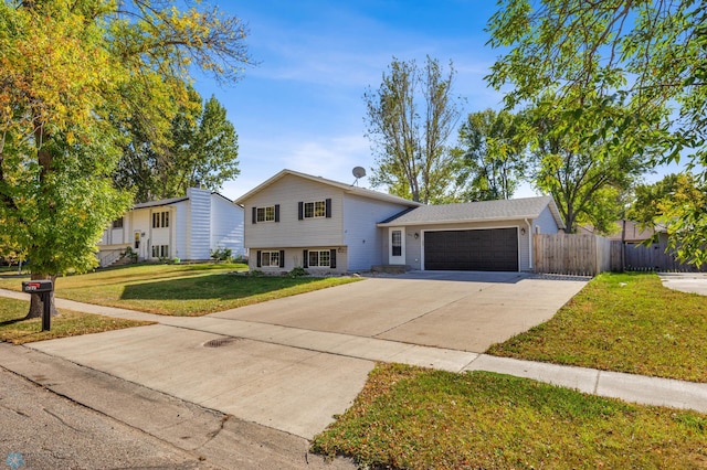 tri-level home featuring a garage and a front lawn