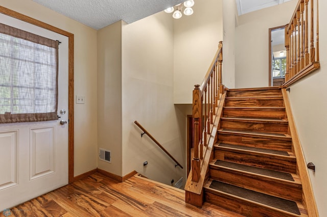 foyer entrance featuring a textured ceiling and hardwood / wood-style floors