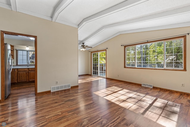 unfurnished living room featuring ceiling fan, vaulted ceiling with beams, dark wood-type flooring, and sink