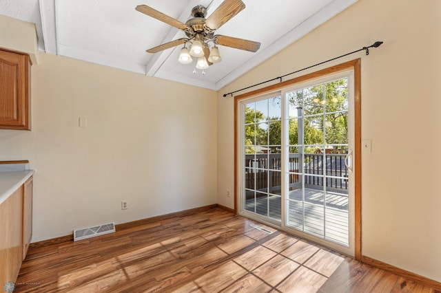 unfurnished dining area featuring ceiling fan, vaulted ceiling with beams, light hardwood / wood-style floors, and a textured ceiling