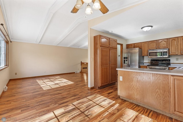 kitchen with ceiling fan, stainless steel appliances, light hardwood / wood-style floors, and kitchen peninsula