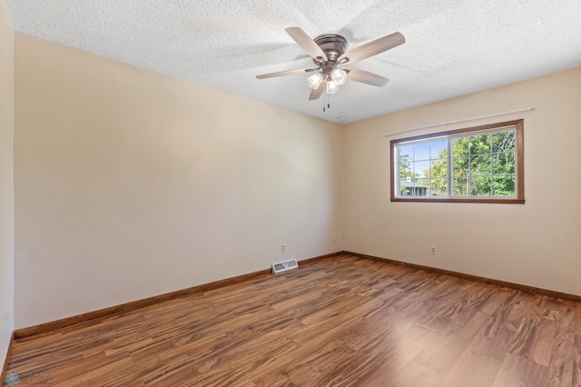 empty room featuring wood-type flooring, a textured ceiling, and ceiling fan