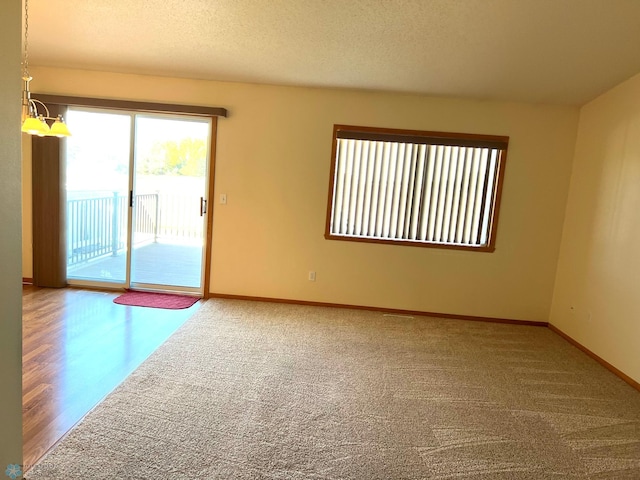 spare room featuring hardwood / wood-style flooring and a textured ceiling