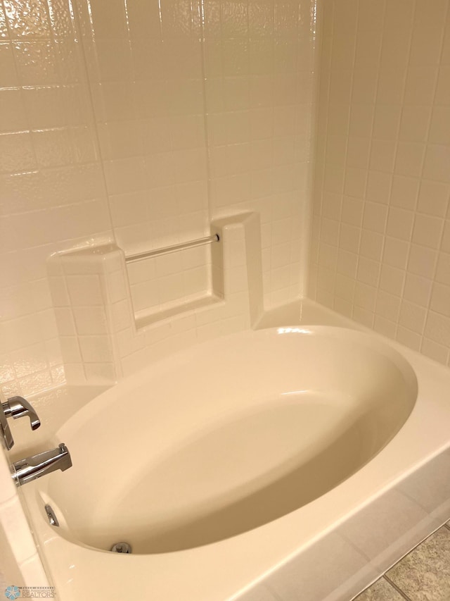 bathroom with tile patterned flooring and a washtub