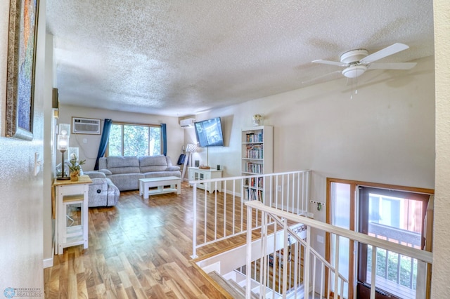 interior space featuring an AC wall unit, hardwood / wood-style flooring, and a textured ceiling