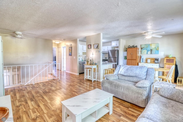 living room with light hardwood / wood-style flooring and a textured ceiling